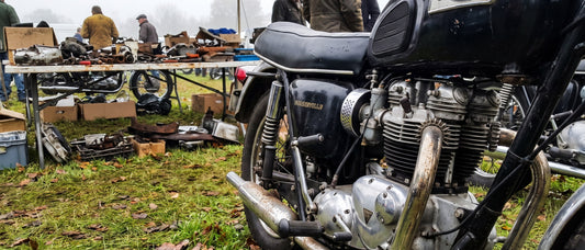 Lambskin motorcycle seat cover topic shown on vintage Triumph Bonneville parked at a shaded swap meet