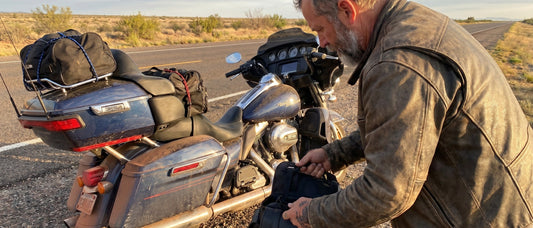 Touring rider on Harley bagger loaded for memorial day long motorcycle ride seat prep on open highway at dawn