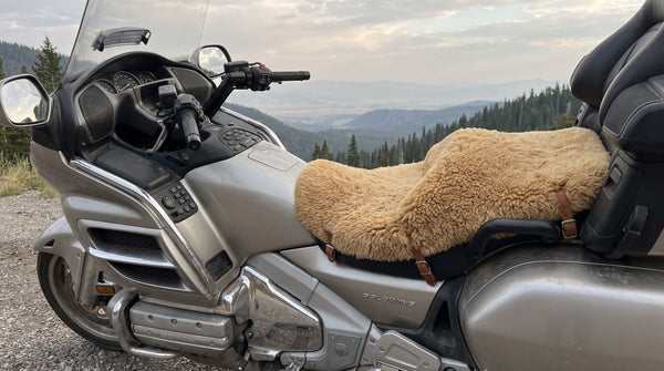 Honda Gold Wing touring bike with a sheepskin motorcycle seat pad on the saddle at a mountain overlook